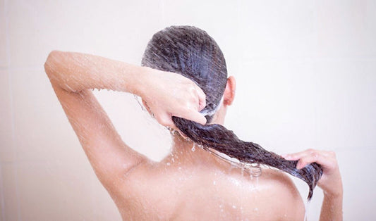 a woman with long brown hair is showering