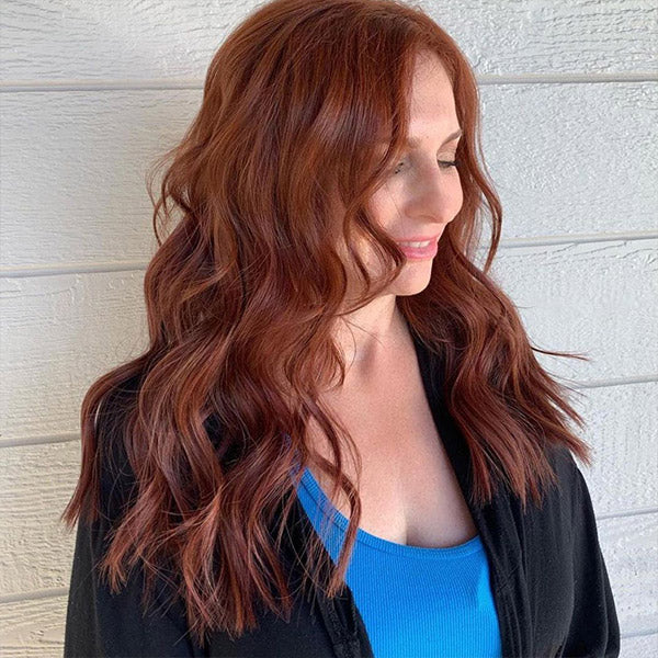 a selife of a lady after wearing long auburn hair extensions